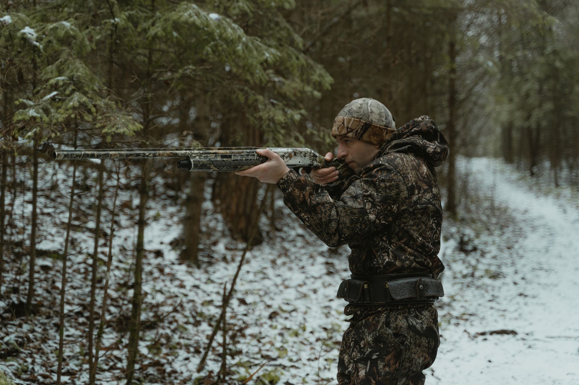 Hunter and guide walking quietly along a woodland trail during a morning stalk