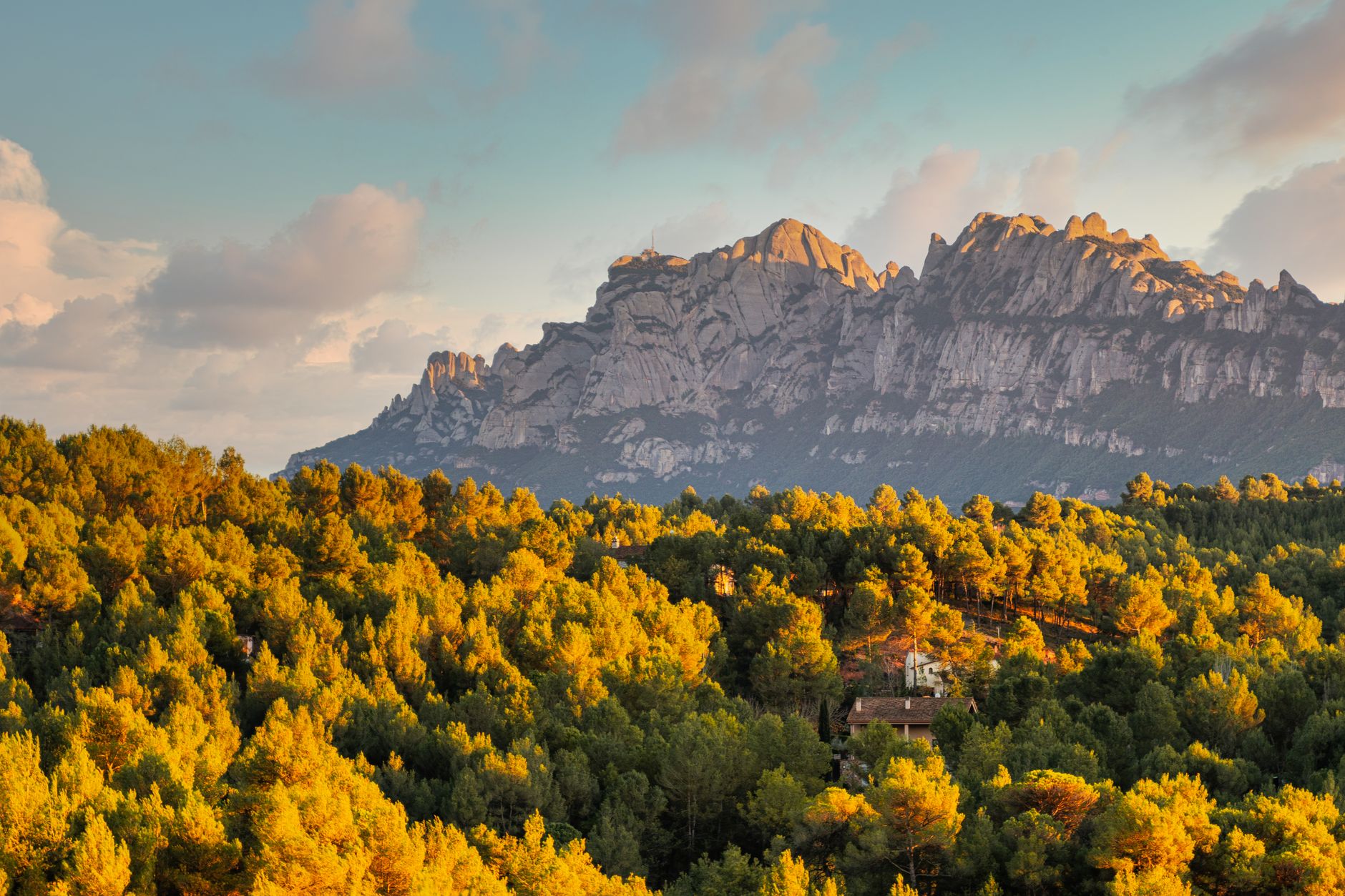Terreno montañoso español al amanecer, hábitat de cabra montés y ciervo rojo